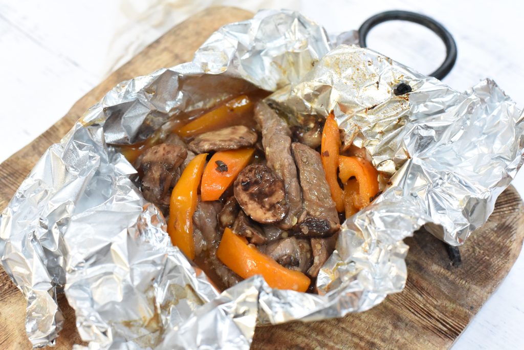 Marinated Steak and Mushroom Foil Packets on a cutting board.