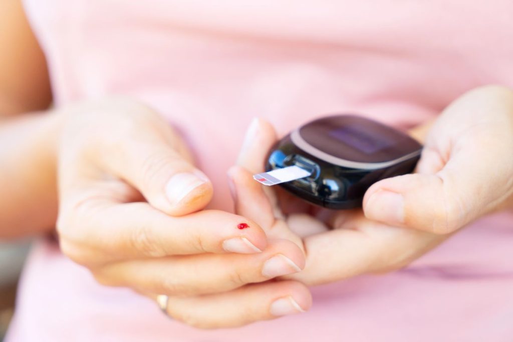 A woman testing her blood sugar.