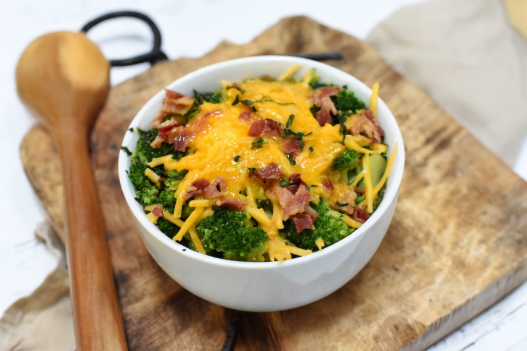 Loaded broccoli in a bowl on a cutting board.